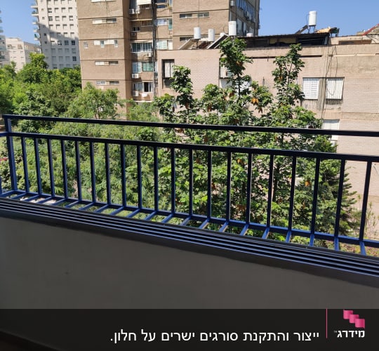 מעקה מתכת כחול במרפסת עם נוף לעצים